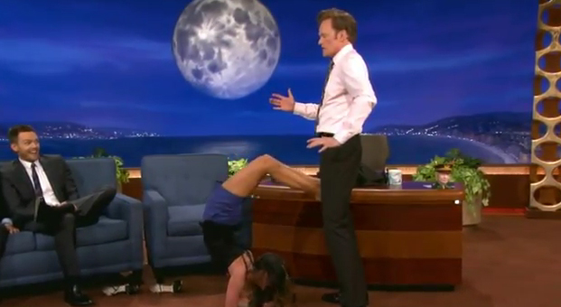 Nina Dobrev hace la postura del escorpión con el presentador Conan O'Brien