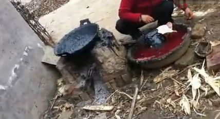 Un vendedor chino utiliza asfalto para cocinar una cabeza de cerdo