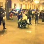 Un hombre en silla de ruedas hace un slalom entre los antidisturbios de la Puerta del Sol