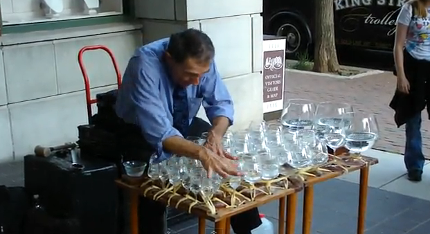 Músico callejero tocando Mozart en vasos de agua