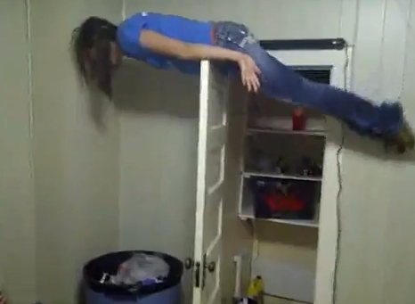 Chica haciendo planking sobre una puerta