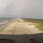 Un avión C-130 Hercules aterrizando en la playa