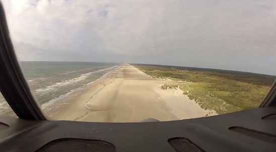 Un avión C-130 Hercules aterrizando en la playa