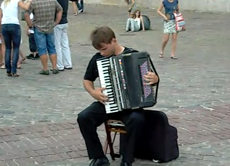 Artista callejero tocando Vivaldi con un acordeón