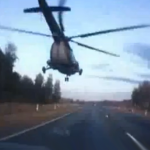 Un helicóptero militar Mi-8 adelanta a una gran cantidad de coches en una autovía rusa