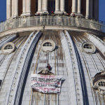 Un hombre se encarama a la cúpula de la basílica de San Pedro en el Vaticano para protestar contra Monti y la UE