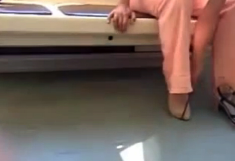 Una mujer intentando ponerse el zapato en el metro