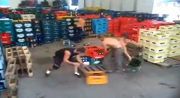 Trabajadores rumanos ordenando cajas de botellas de cerveza vacías