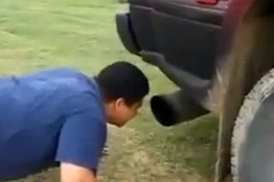 Idiotas que ponen la cara delante del tubo de escape de un coche