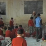 Un hombre da clases a niños pobres en una escuela improvisada debajo de un puente