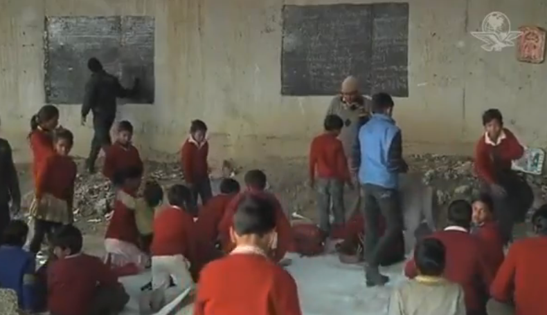 Un hombre da clases a niños pobres en una escuela improvisada debajo de un puente