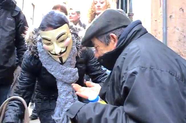 En medio de una manifestación, los líderes de esta se paran para ayudar a un indigente