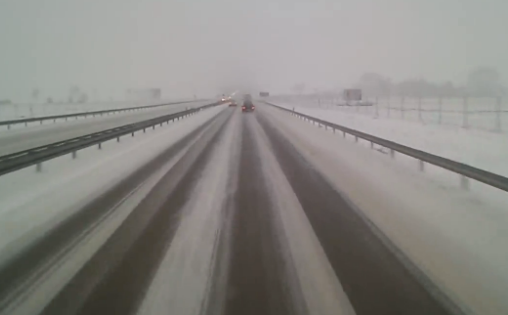 El conductor de un camión pierde y recupera el control en una carretera nevada