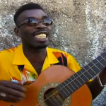 Brushy One String cantando 'Chicken In The Corn' acompañado de una guitarra de una sola cuerda