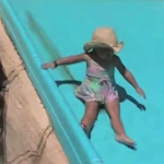 Una niña se hace caca mientras que se desliza por el tobogán a la piscina