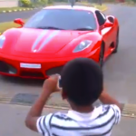 Un niño pequeño conduciendo un Ferrari