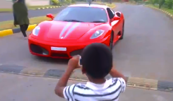 Un niño pequeño conduciendo un Ferrari