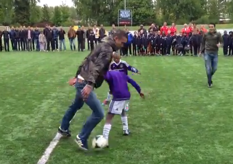 Robin van Persie demostrando su habilidad con el balón frente a un grupo de niños