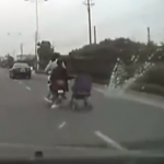 Una mujer china lleva un carrito de bebé de remolque en su moto
