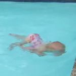 Niña pequeña cruza la piscina buceando