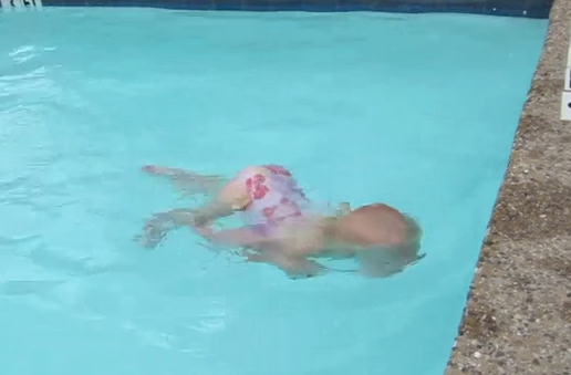 Niña pequeña cruza la piscina buceando