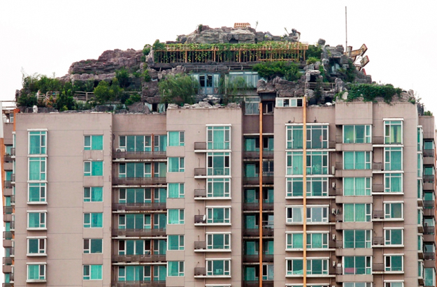 Un hombre chino se construye un monte en lo alto de un bloque de pisos