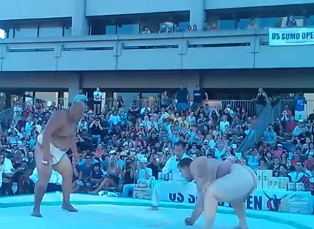 Luchador de sumo levanta a su adversario y lo lanza al suelo