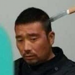 Un chino espera paciente su turno en un hospital con un cuchillo en la cabeza
