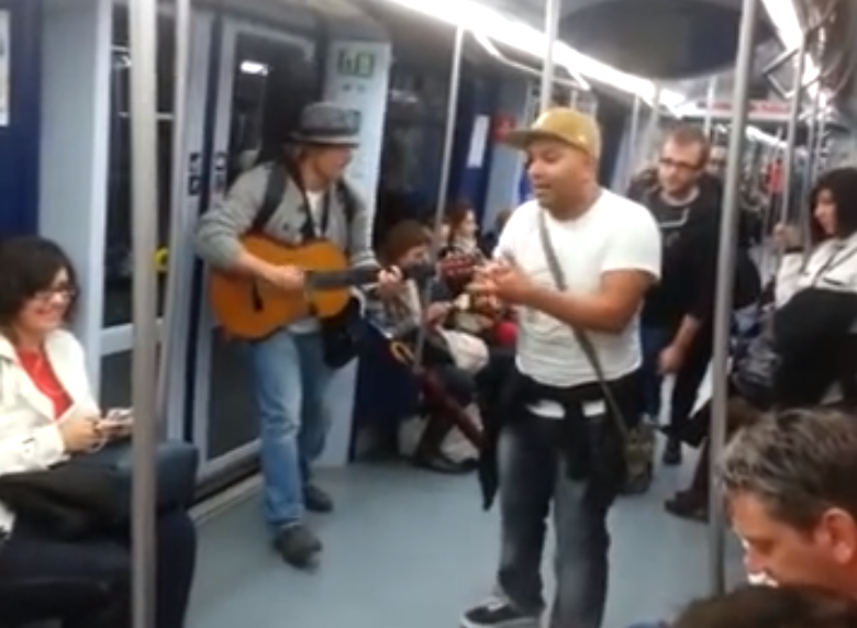 Artista callejero improvisando pasajero a pasajero en el metro de Madrid