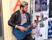 Un artista callejero tocando la guitarra en la calle... con final sorpresa