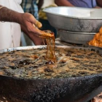 Un cocinero indio mete las manos como si nada en aceite hirviendo