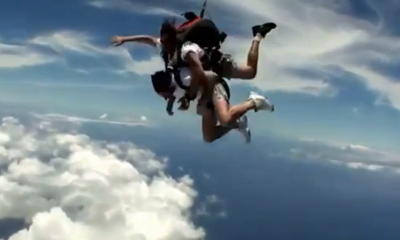 Instructor metiéndole ganchos de derecha a un alumno durante un salto en paracaídas