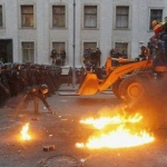 Manifestantes europeístas de Kiev derriban una barricada de la policía con una excavadora