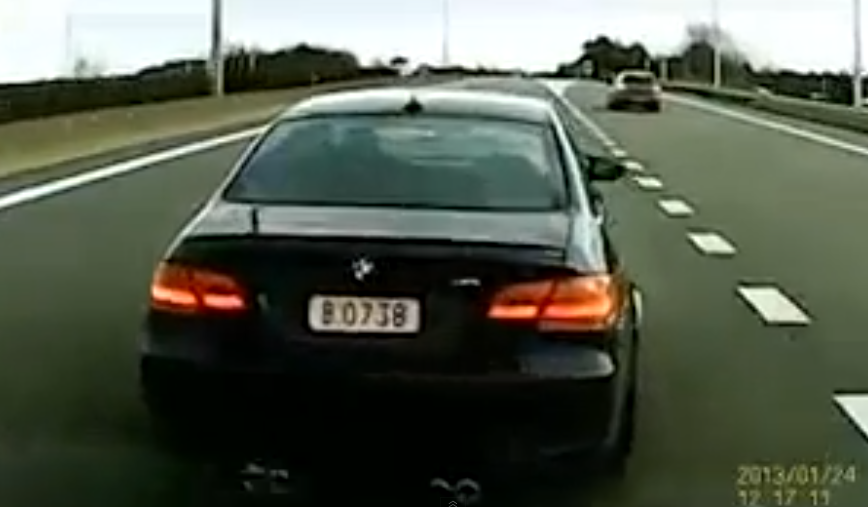 Conductor de un BMW M3 pisando el freno delante de otro coche después de adelantar por la derecha