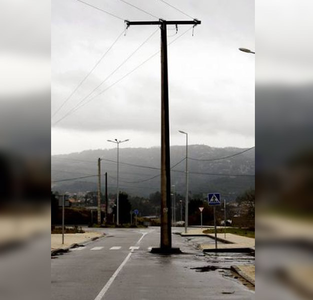 Una carretera abierta al tráfico con un poste de la luz en mitad de uno de los carriles (Galicia)