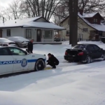 Conductor ayudando a un coche de policía atrapado en la nieve