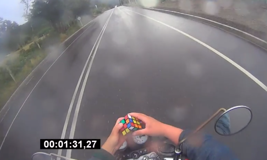 Hace cubo de Rubik mientras circula en moto