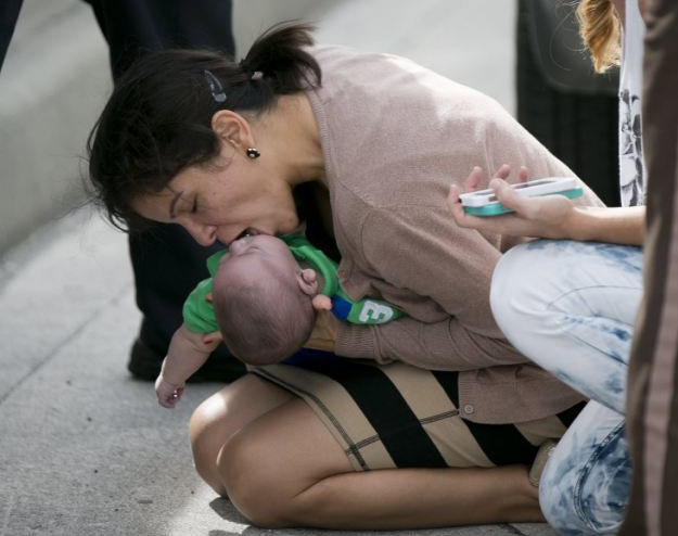 Una mujer salva con un boca a boca a un bebé en medio de una carretera