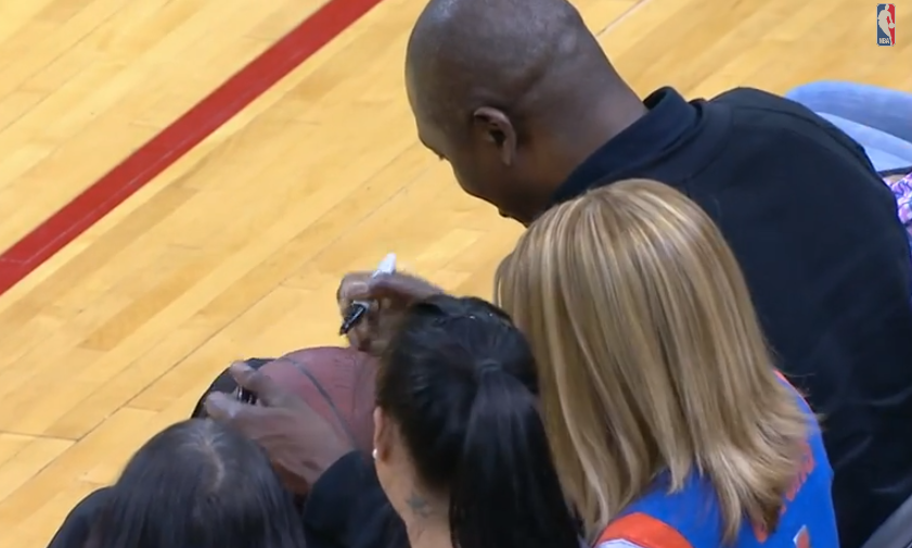 Fan de los Rockets atrapa el balón firmado por Hakeem Olajuwon y se lo entrega a un niño