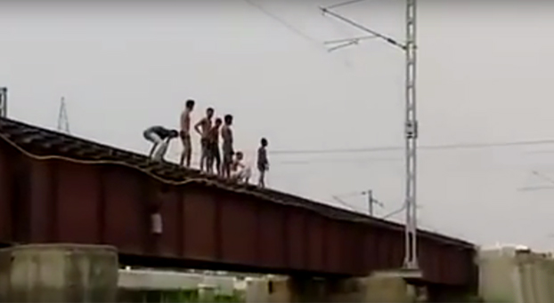 Niños indios saltan desde la vía al río justo cuando llega el tren