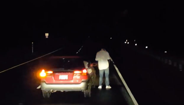 Este conductor borracho para su coche en mitad de la carretera para mear