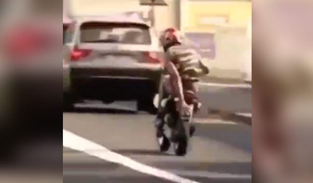 Tapa la matrícula de su moto con la mano al pasar por delante de los policías y acaba de la siguiente manera...