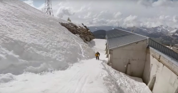 Slow motion: Backflip doble entre un edificio y un monte de roca