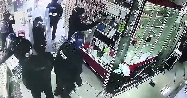 La policía antidisturbios grabada saqueando teléfonos en una tienda de un centro comercial