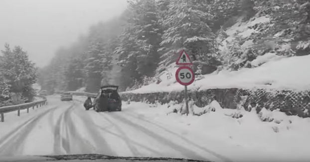 ''¿Poniendo cadenas?, ¿en serio? Pero si no hay nieve para poner cadenas. Cariño, esto en Suiza no pasa''