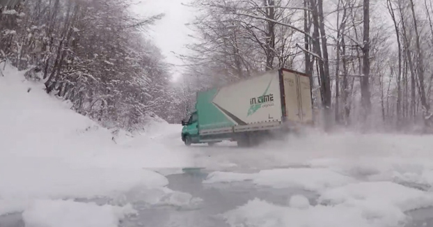 Camionero tomando las curvas derrapando en una carretera de montaña nevada