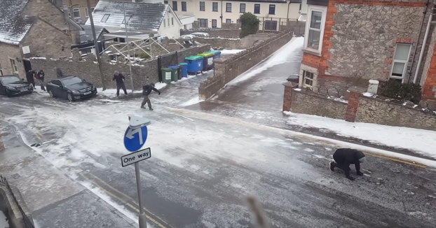Vecinos intentando subir la calle con el suelo totalmente congelado