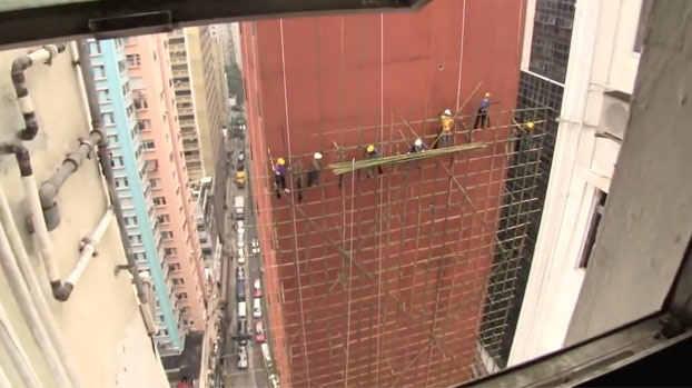 Obreros levantando un andamio de bambú en un edificio de Hong Kong