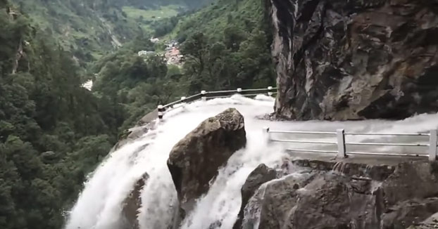 Peligrosa carretera de montaña en Nepal que pasa por en medio de una cascada