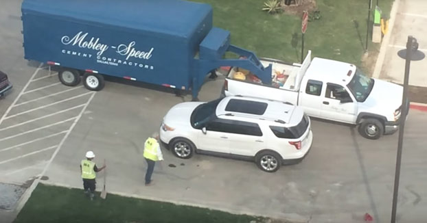 Unos vecinos ven cómo los obreros terminan de poner un parche de hormigón pero se olvidan de señalizarlo